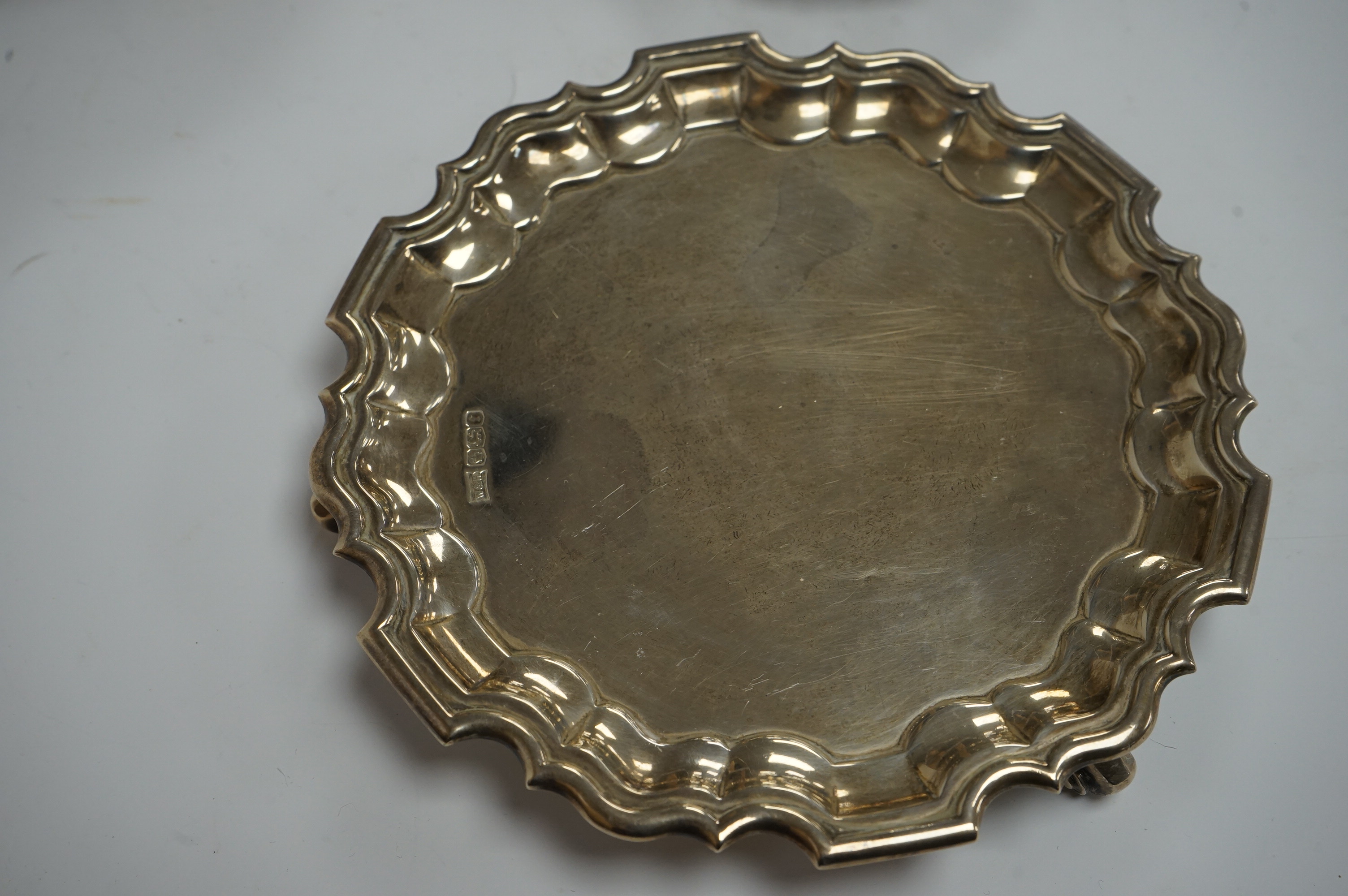 A George V silver waiter, by Walker & Hall, with pie crust border on three scroll feet, Sheffield, 1923, 15.6cm, together with a George V silver sauceboat and a small repousse silver bonbon dish, 9.9oz. Condition - fair